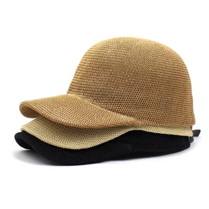 Close-up of woven straw baseball caps in dark brown, light beige, and black colors