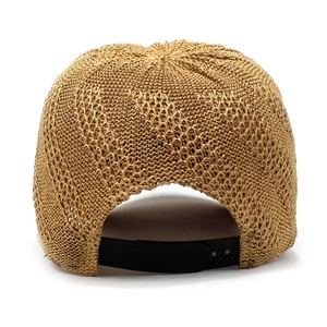 Detail of light brown straw baseball cap featuring intricate weave and black strap