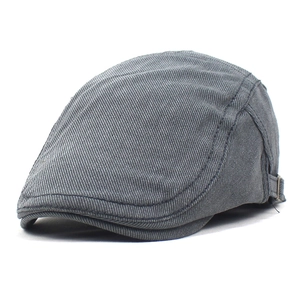 Détail de béret en coton gris montrant la boucle métallique réglable et coutures