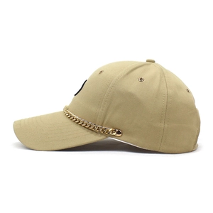 Close-up of khaki baseball cap with gold chain decoration on the curved brim detail