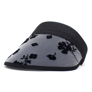 Dettaglio cappello parasole nero con tesa in rete e motivi floreali floccati