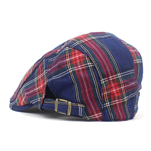 Detail of classic red plaid cotton beret featuring an adjustable bronze metal buckle