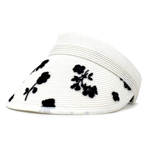 Dettaglio di motivi a fiori e farfalle su un cappello parasole intrecciato crema