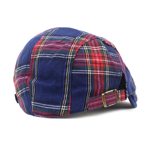 Detail of adjustable bronze metal buckle and tartan pattern on the cotton flat cap