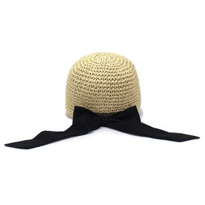 Elegant beige woven straw baseball cap with a large black fabric bow decoration