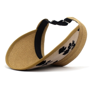 Dettaglio del cappello da sole in paglia con ricamo floreale nero e cinturino regolabile