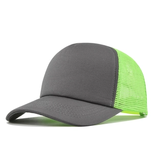 Detailed close-up of dark grey cotton fabric and neon green breathable mesh on truck hat