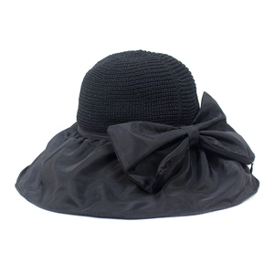 Detail of elegant black sun hat showing breathable straw texture and glossy bow decoration
