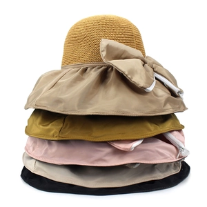 Vertical stack of multi-colored straw sun hats featuring elegant bow detail and wide brims