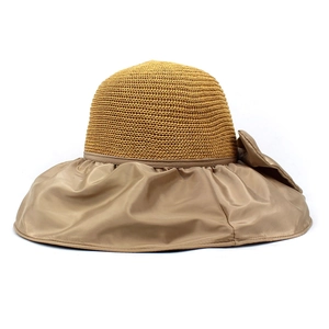 Close-up of a summer sun hat featuring woven straw texture and elegant bow decoration