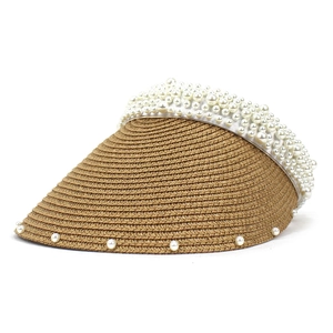 Close-up of woven straw sun visor with pearl cluster embellishments on a white background