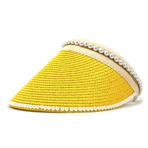 Close-up of vibrant yellow straw sun visor with elegant white pearl bead trim details