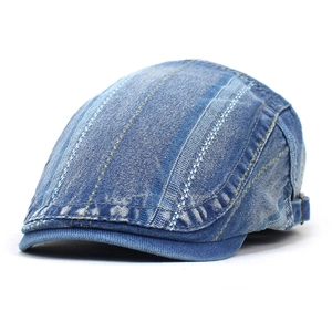 Detailed close-up of light blue washed denim beret cap with contrast yellow stitching