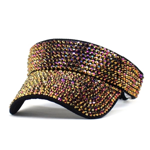 Detailed view of shimmering purple and gold rhinestones on a black sun visor hat