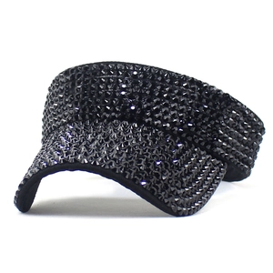 Close-up of black sun visor hat with sparkling rhinestones and curved brim for women