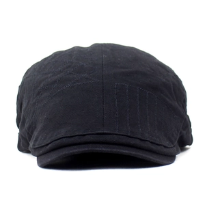 Détail de la casquette plate en coton noir avec broderie géométrique et surpiqûres