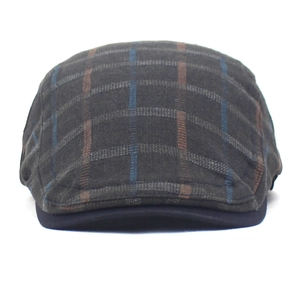 Detailed close-up of a vintage dark grey plaid flat cap with woven texture and blue pattern
