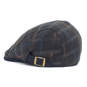 Detail view of adjustable metal buckle and vintage plaid fabric texture on the flat cap