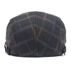 Detail view of dark grey plaid flat cap with adjustable metal side buckle and retro pattern