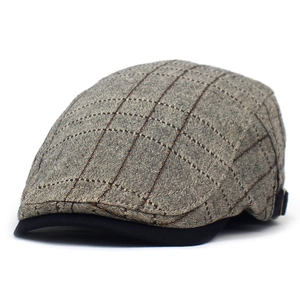 Détail de la casquette plate en coton avec motif à carreaux marron et boucle latérale en métal
