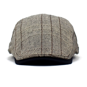 Détail du béret vintage à carreaux en coton avec texture tissée et visière noire