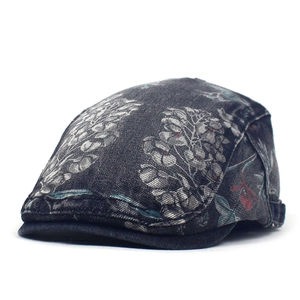 Detail van vintage denim baret met bloemenpatroon en verstelbare metalen zijgesp aan de zijkant