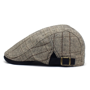 Gros plan sur le béret à carreaux marron avec sangle réglable noire et boucle en bronze