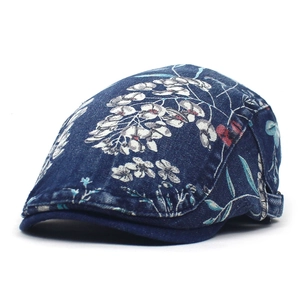 Detailopname van blauwe denim baret met witte bloemenprint en verstelbare zijgesp
