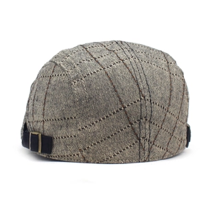Détail d'une casquette en coton à carreaux avec boucle métallique réglable et coutures