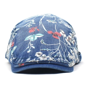 Gedetailleerd zicht op de donkerblauwe denim baret met vintage bloemenprint en katoentextuur