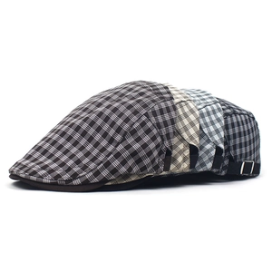 Detail of British plaid flat caps showing four classic patterns and adjustable metal buckles
