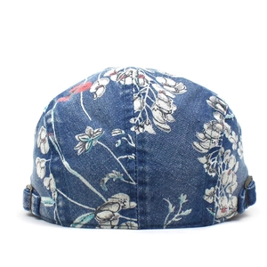 Detailweergave van denim baret met bloemenprint en verstelbare metalen zijgespen