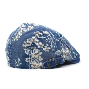 Vintage denim baret met bloemenprint en verstelbare koperen gesp op witte achtergrond
