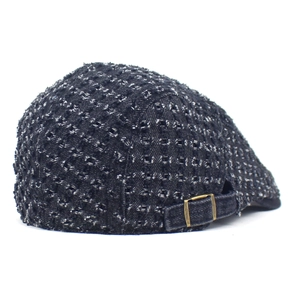 Close-up of distressed denim beret featuring raw texture and vintage metal side buckle