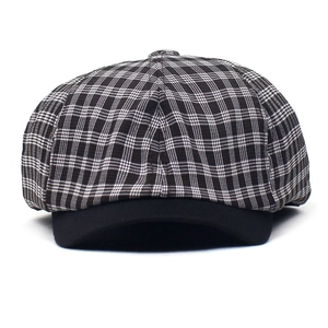 Detailed close-up of a plaid baker boy hat with a black brim and octagonal crown pattern
