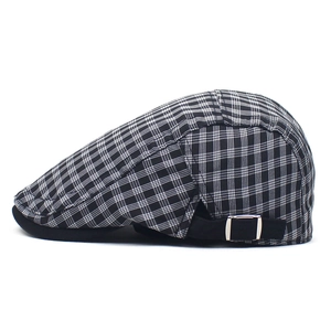 Detail view of plaid flat cap with side adjustable metal buckle and woven texture