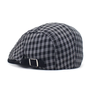 Detail view of the black and white plaid beret with adjustable metal buckle back strap