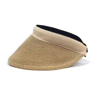 Detail of woven straw sun visor with wide brim and light brown satin ribbon trim