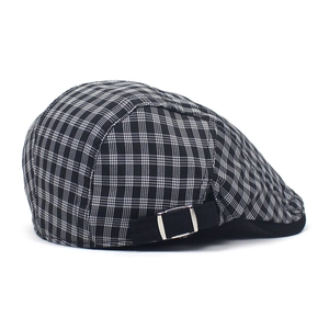 Close-up of black and white plaid cotton beret featuring a silver metal buckle detail