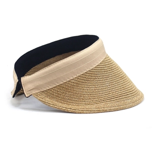 Close-up of woven straw sun visor with cream ribbon detail and black fabric lining