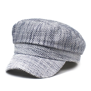Vista dettagliata della trama in tweed bianco e blu di un berretto stile marinaio da donna