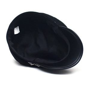 Detailed interior of black navy cap showing fabric care label and metal chain accent