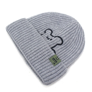 Detailed close-up of grey ribbed knit beanie with bear embroidery and side label