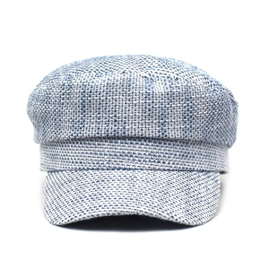 Dettaglio del berretto newsboy in tweed blu e bianco che mostra la trama del tessuto