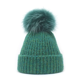 Deep green winter knit beanie with a large matching pompom and ribbed texture