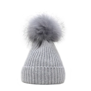 Women's winter light gray knit beanie hat with large fluffy faux fur pompom decoration