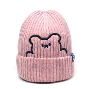 Close-up of pink knit beanie featuring cute cartoon bear embroidery and blue brand label