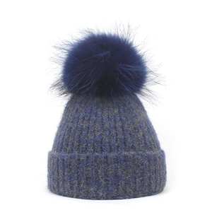 Close-up of mixed knit beanie with a large faux fur pompom and wide cuffed hem