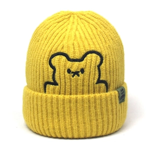Detail view of a bright yellow knitted beanie featuring a minimalist black bear embroidery