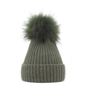 Women's warm winter knitted hat in dark green with a large pom-pom and ribbed cuff design